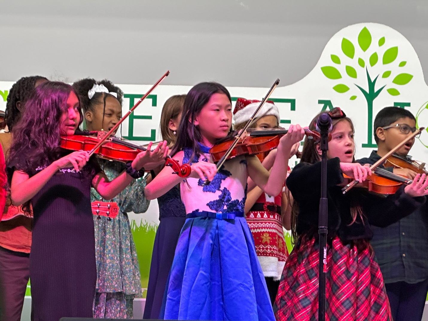 A group of girls playing violinsDescription automatically generated